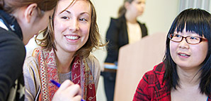 A group of women of different races talking together and smiling.