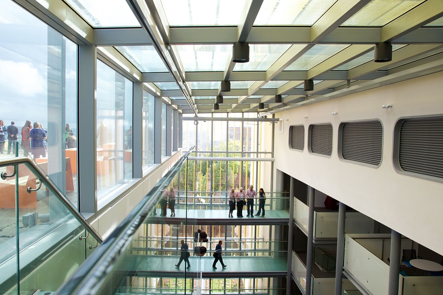 people walking across multi-level walkways and gathering out on a rooftop terrace.