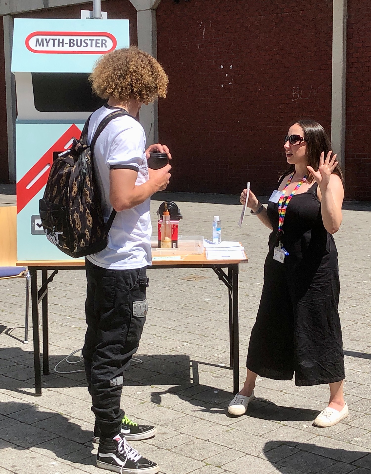 An image of researcher Dr Jamsine Khouja talking to a member of the public.