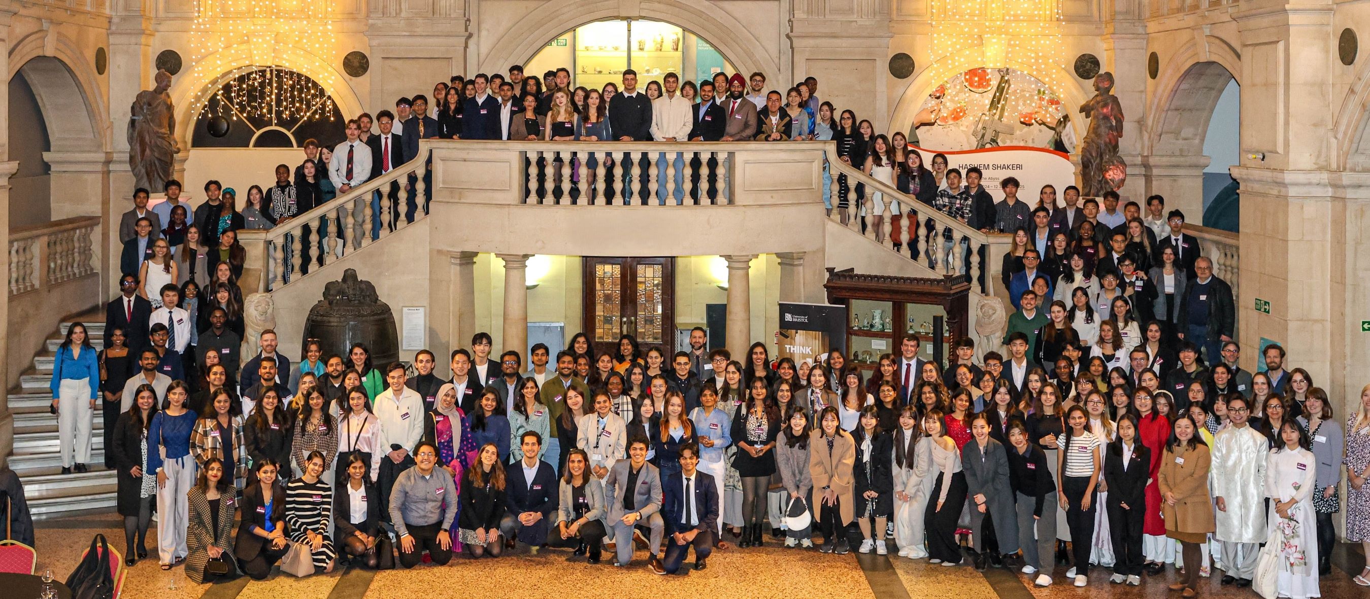 A large group of Scholars crowded around a set of stairs in Bristol Museum