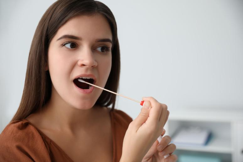 a woman takes a mouthswab sample