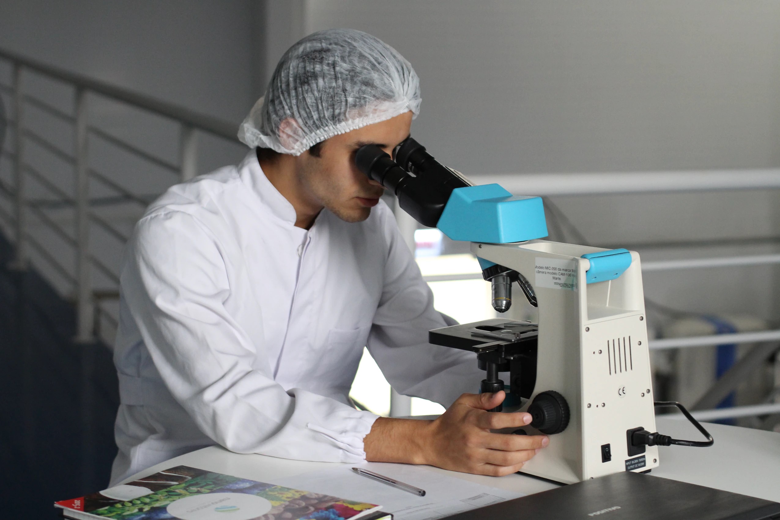 A person performing diagnostics via microscope.