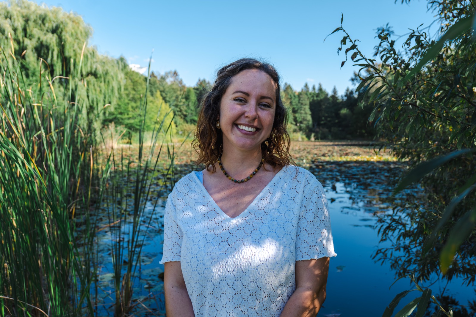 A young woman standing by a lake