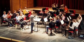 The orchestra rehearse on stage in the auditorium. 