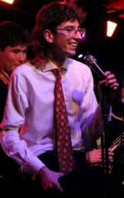 A student in shirt and tie holding a microphone