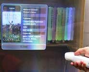 A prototype bookcase featuring online information about a selected book, projected back over it