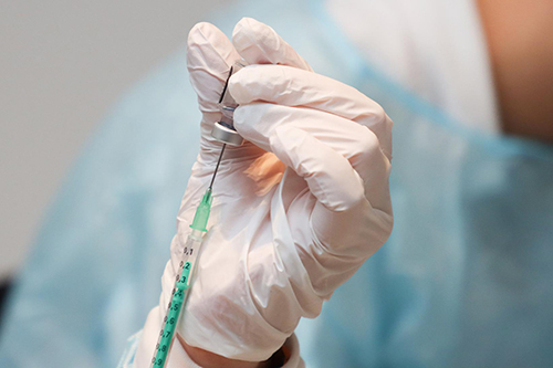 A health care worker preparing a COVID-19 vaccine dose