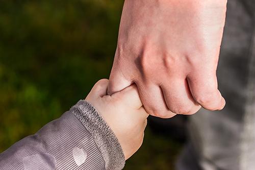 A child and parent holding hands