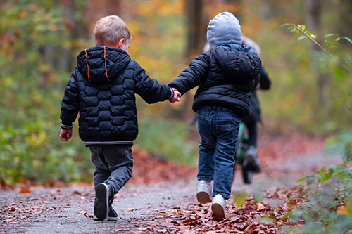 Two young children walking along a path