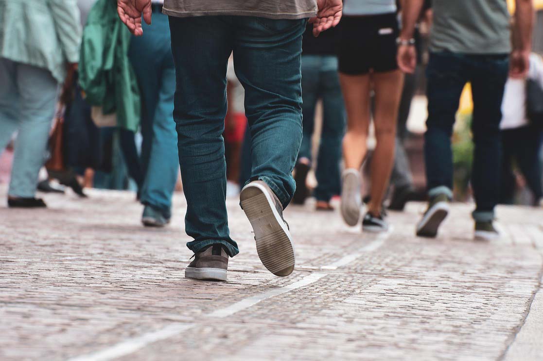 View of people's legs walking along the pavement