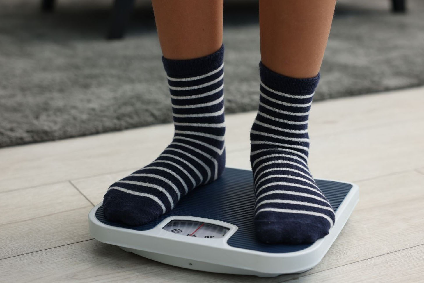 A young person standing on weighing scales
