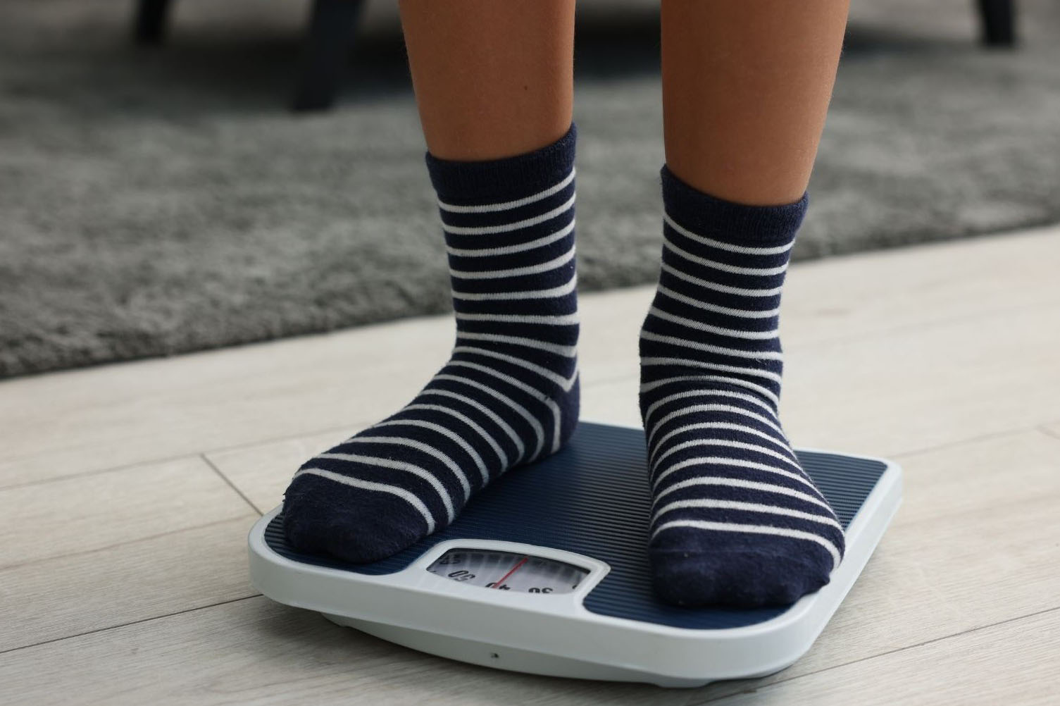 A young person standing on weighing scales