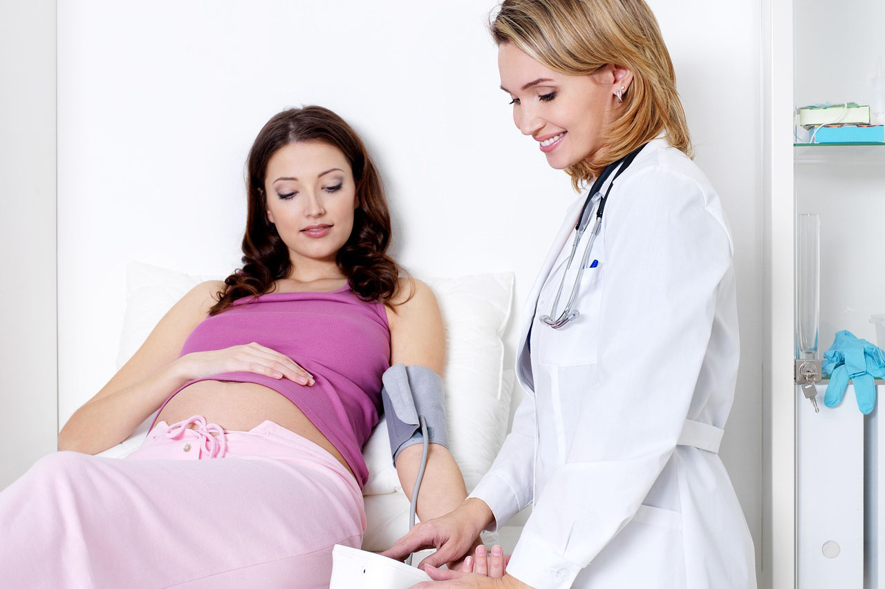 A stock-free image of a pregnant woman having her blood pressure taken