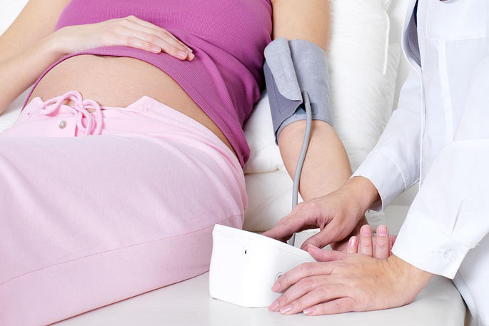 A stock-free image of a pregnant woman having her blood pressure taken