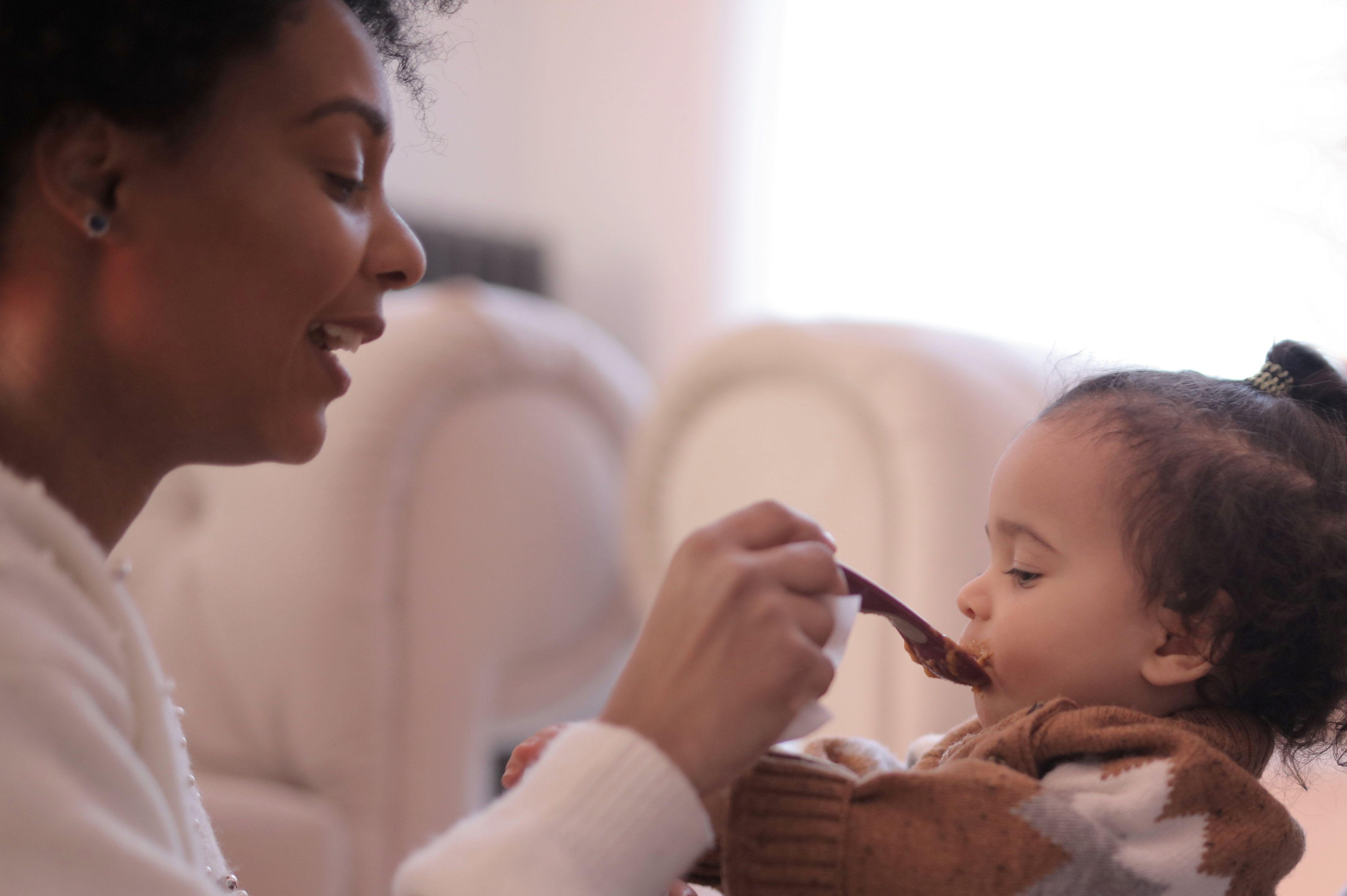 A women feeding a toddler