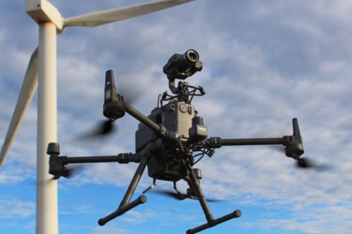 Photo of a drone and a wind turbine