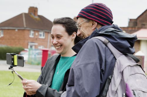 Two people looking at a mobile phone which has the Future Spaces Toolkit technology