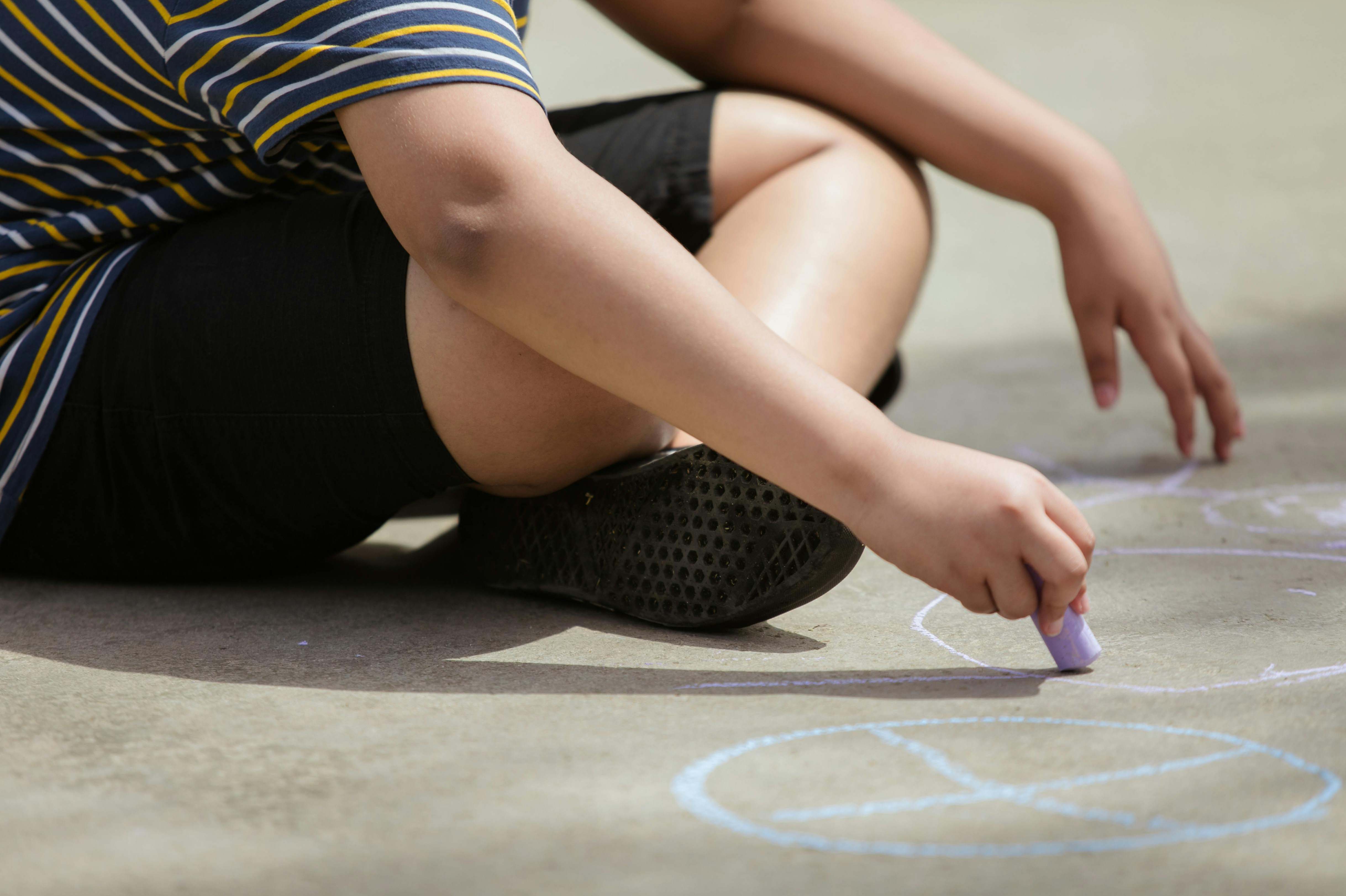 A child drawing with chalk on an outdoor pavement Credit RDNE Stock project from Pexels