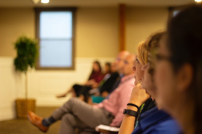 People seated in a room listening to a talk or lecture.