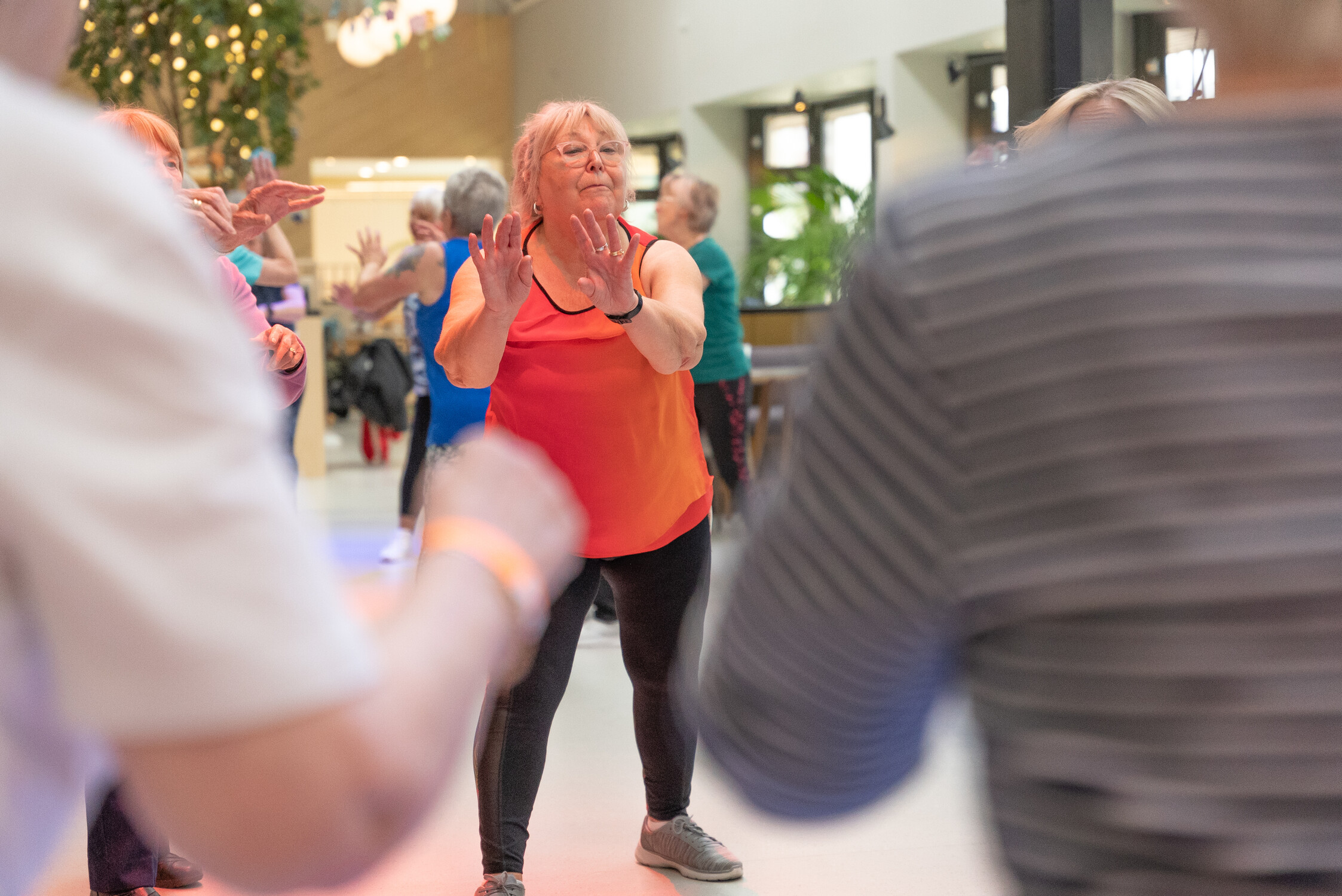 A group of older people keeping fit in an exercise class.