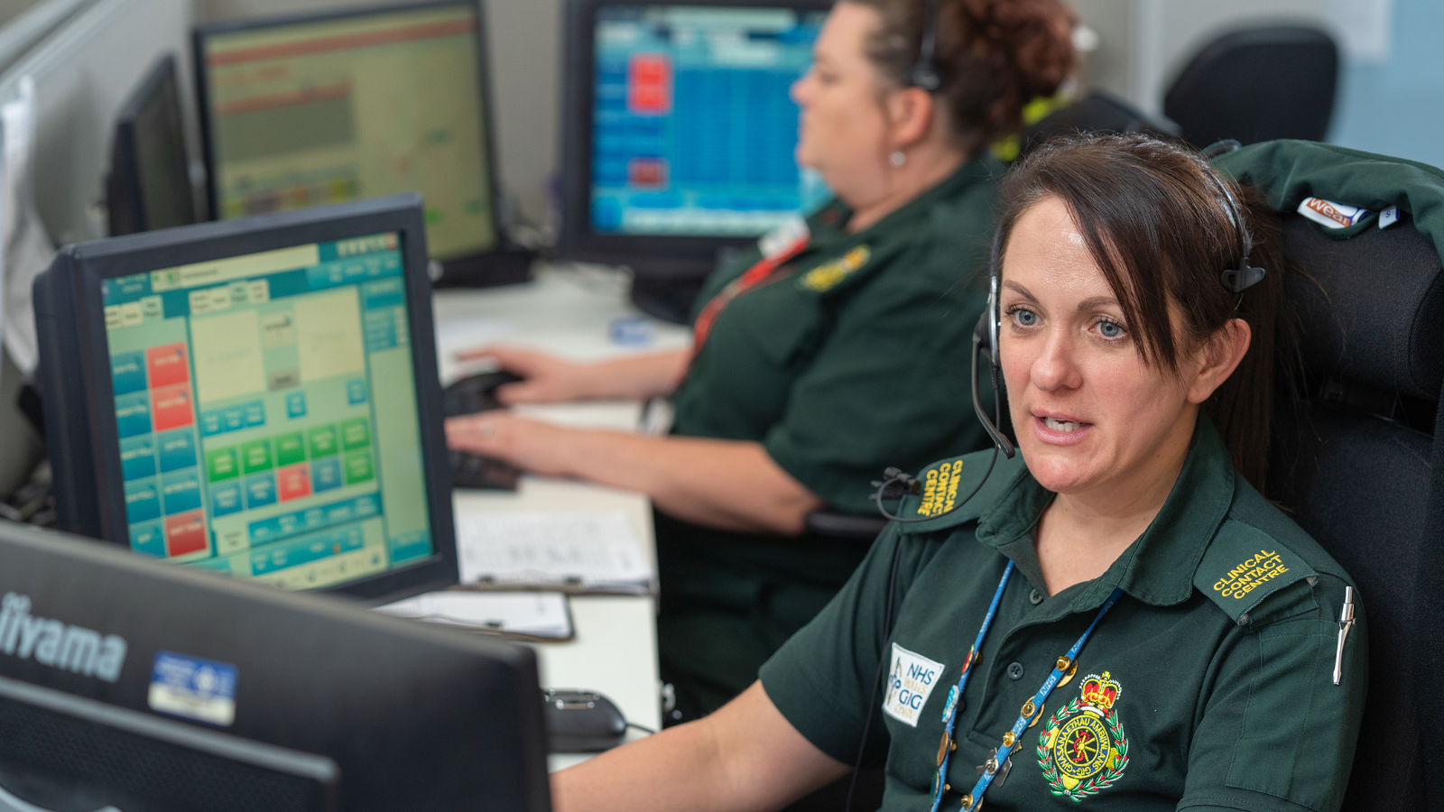 999 call responders sitting at desks and screens.