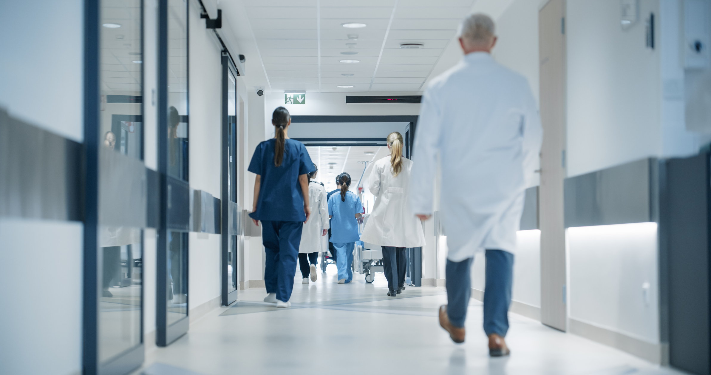 Medical professionals walking down a hospital corridor.
