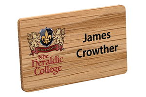 a small light brown wooden badge with black writing on