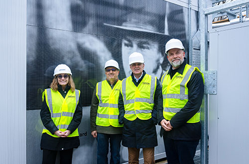 Four people in hi-vis jackets stand in front of Isambard