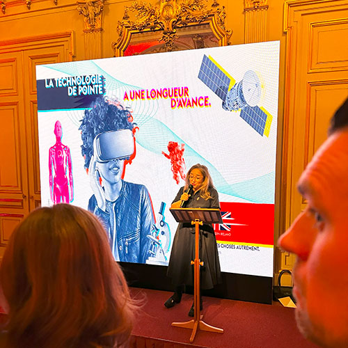 A women is standing on stage giving a talk