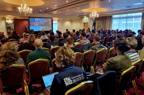 Room full of people watching a talk