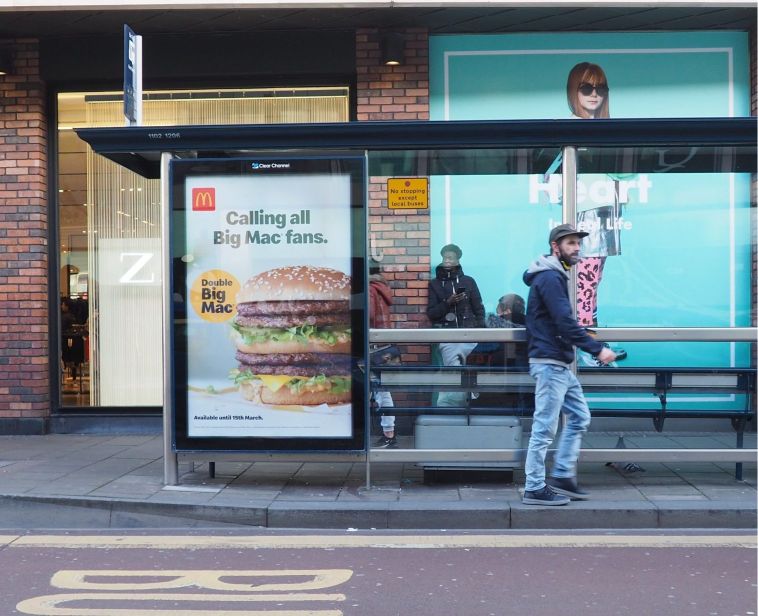 A McDonald's advertisement at a bus stop in a city