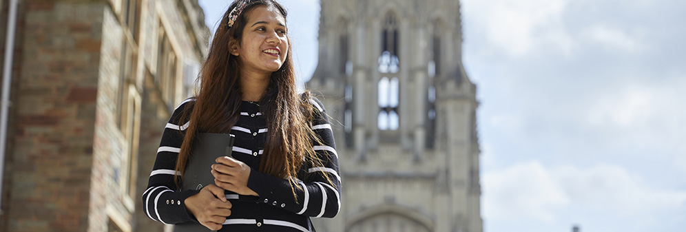 Female student with laptop outside Wills Memorial Building