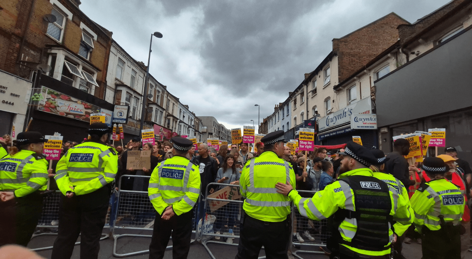 Image of police facing a crowd of protesters behind a barricade