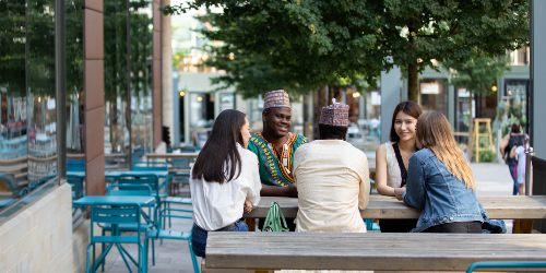 Students sitting at a bench outside