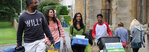 学生携带箱子和袋子搬进大学宿舍。