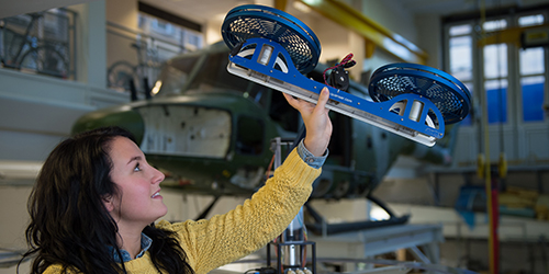 A student holds up a piece of equipment.
