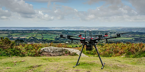A large drone perched on a hilltop overlooking the countryside.