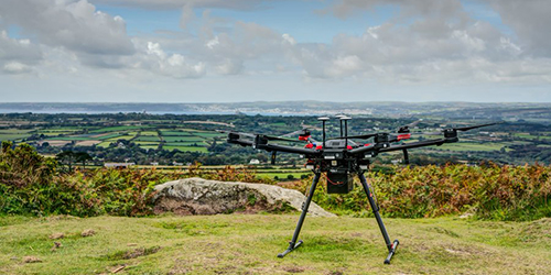 A large drone perched on a hilltop overlooking the countryside.