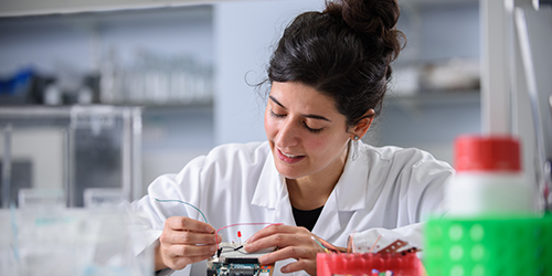 A student working with a piece of laboratory equipment.