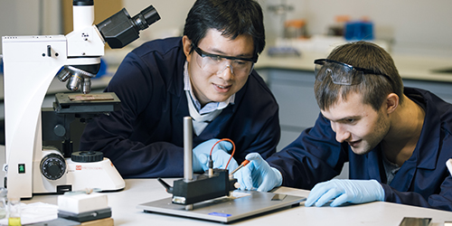 Two students looking at some equipment together.