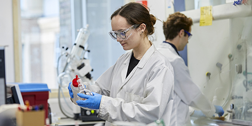 A student wearing PPE using equipment in a laboratory.