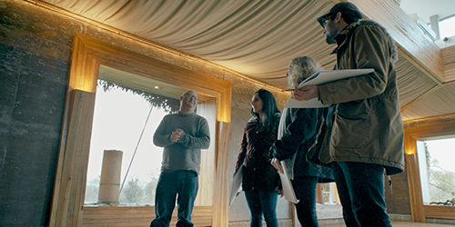 Four people standing together holding large pads of paper.