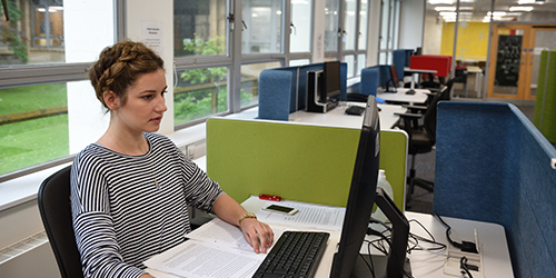 A student focuses on their work at a computer