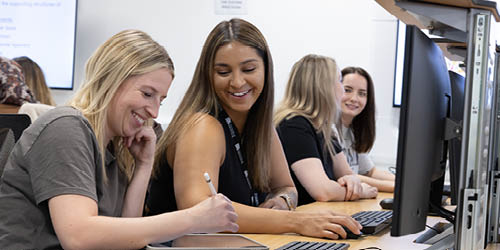 Students working at computers smiling