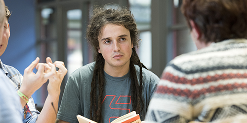 A student listens in a small-group discussion