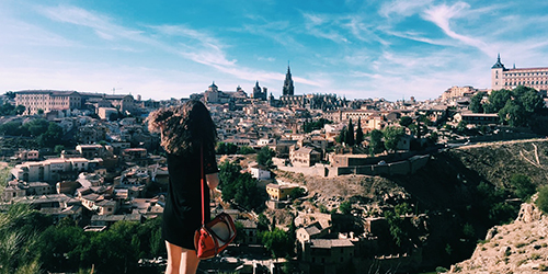 A person overlooking lots of stone buildings in an old city.