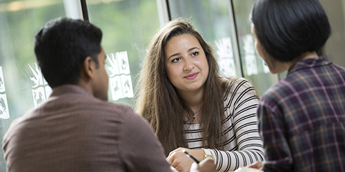 A group of people talking around a table.