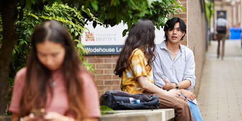 Two students sat outside chatting