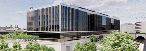 A large glass-fronted building surrounded by greenery.