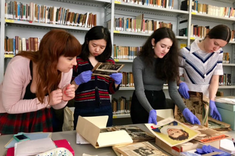 4 students looking at objects